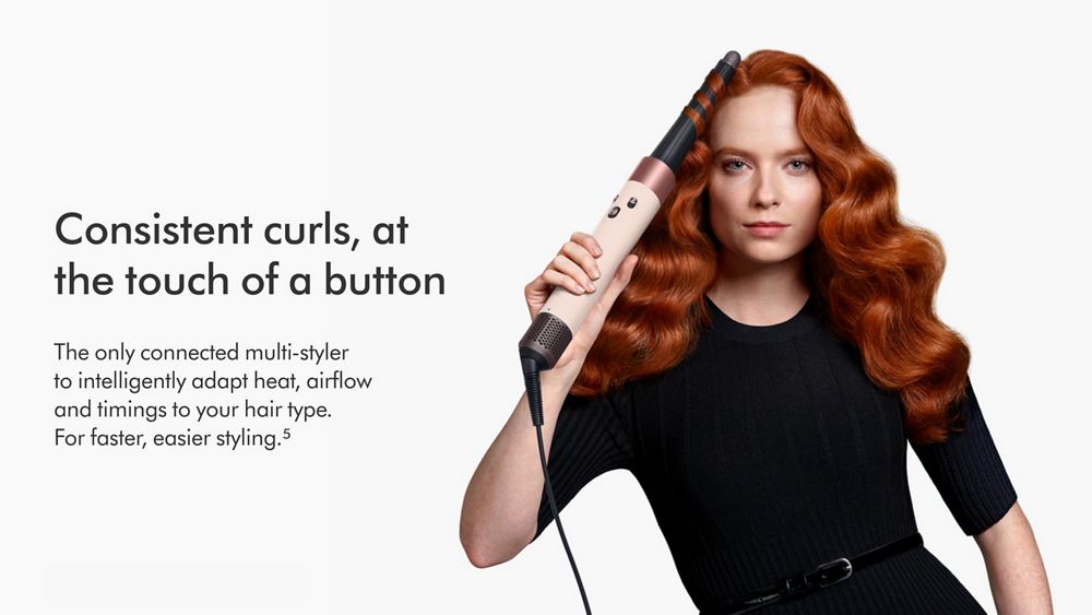 Woman curling hair with the Dyson Airwrap i.d. multi-styler. Consistent curls at a touch of a button.